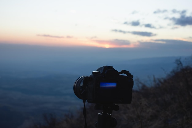 Fotograf fotografuje zachód słońca w górach