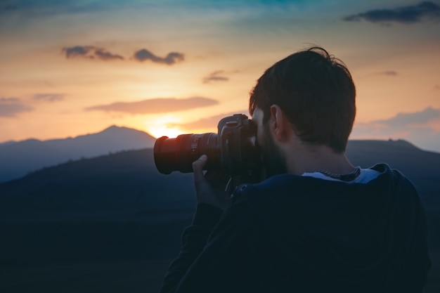 Fotograf Fotografuje Zachód Słońca W Górach