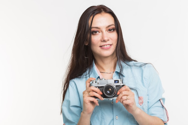 Fotograf, hobby i koncepcja ludzie - Młoda brunetka kobieta z aparatem retro na białym tle.