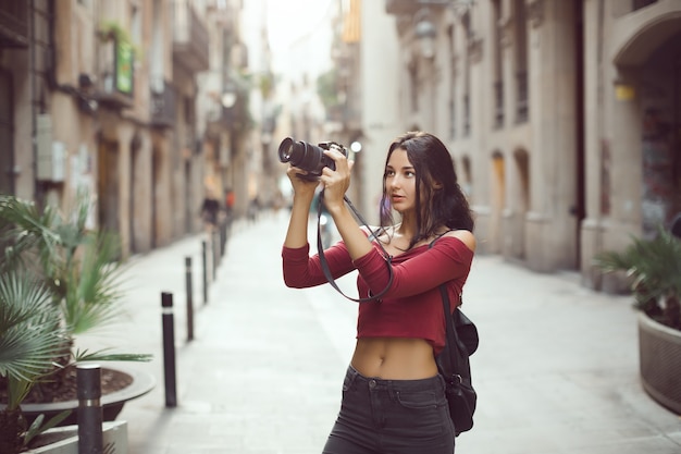 Fotograf kobieta atrakcyjny turystyczny robienia zdjęć z aparatu dslr na zewnątrz w ulicy miasta