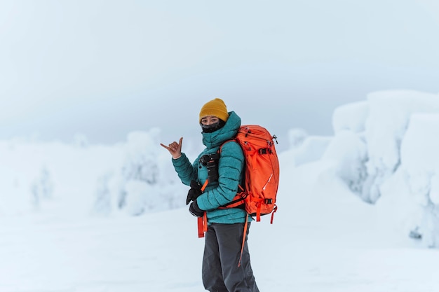 Fotograf krajobrazu robi znak shaka w śnieżnym krajobrazie