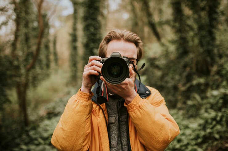 Zdjęcie fotograf mężczyzna robi zdjęcie na zewnątrz podróży
