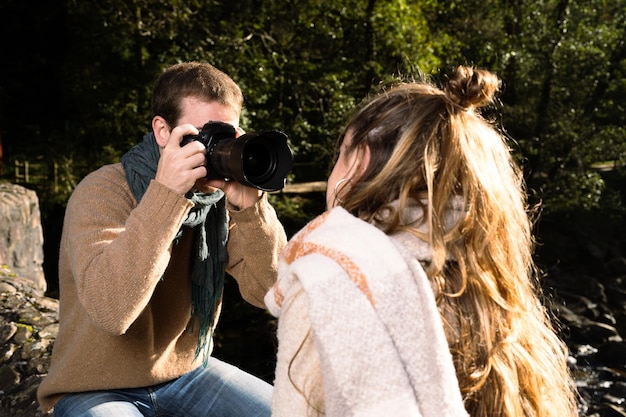 Fotograf pracujący z modelką na świeżym powietrzu w parku