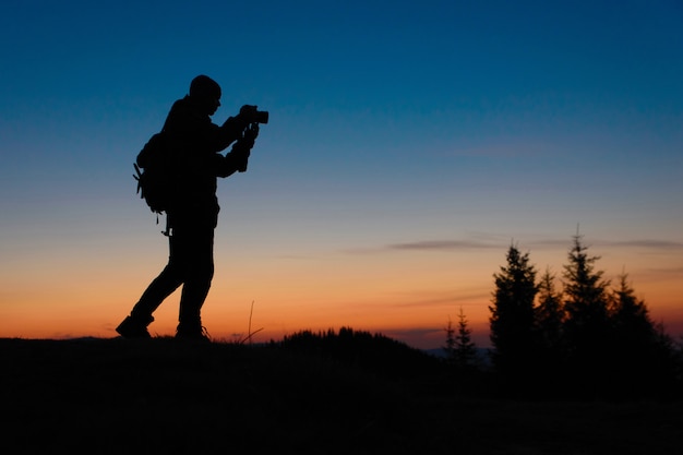 Fotograf Pracuje Z Kamerą Przy Zmierzchem Outdoors