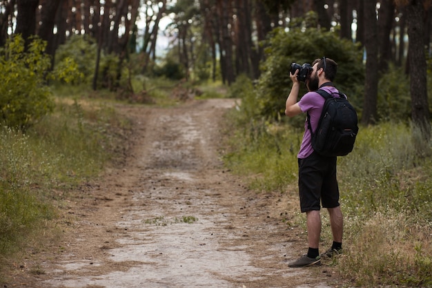 fotograf przyrody. człowiek z aparatem w lesie. styl życia na wędrówki i podróże