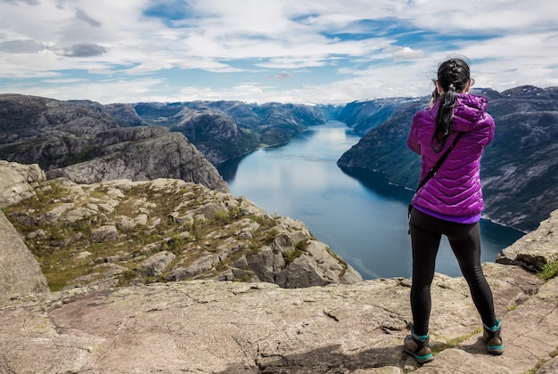 Fotograf przyrody turysta z pędów aparatu, stojąc na szczycie góry. Piękna przyroda Norwegia Preikestolen lub Prekestolen.