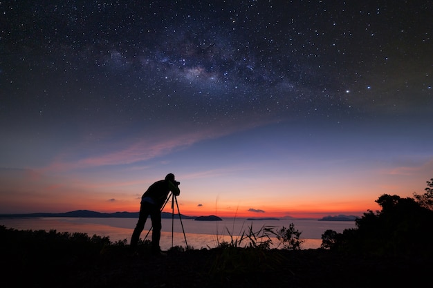 Fotograf robi fotografia wschód słońca z galaktyki Drogi Mlecznej.