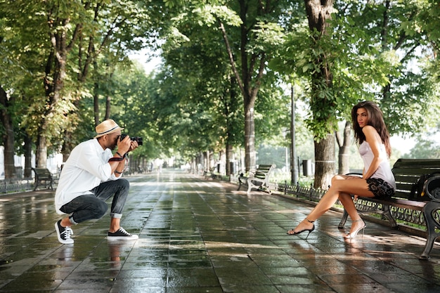 Fotograf robi zdjęcie młodej pięknej brunetki w parku