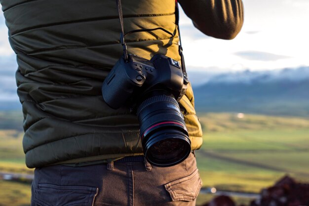 fotograf trzymający aparat w naturze z bliska