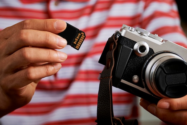 Zdjęcie fotograf z aparatem fotograficznym i kartą pamięci sd