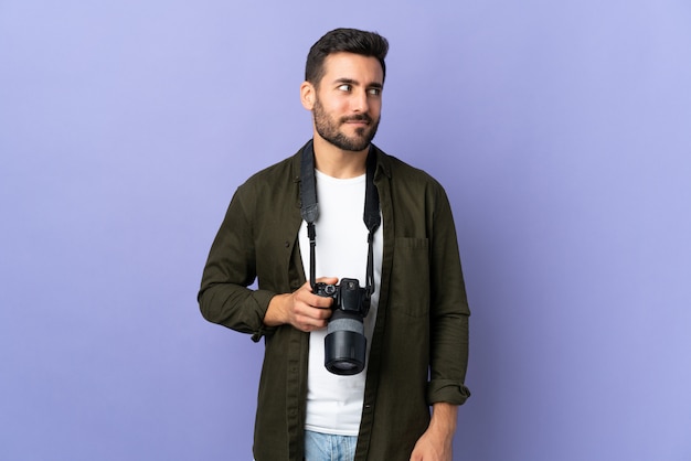 Fotografa mężczyzna nad odosobnioną purpury ścianą ma wątpliwości podczas gdy patrzejący stronę
