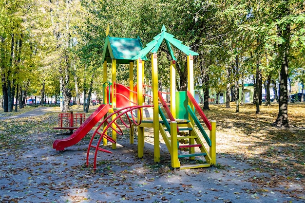 Fotografia na temat pustego placu zabaw z metalową zjeżdżalnią dla dzieci