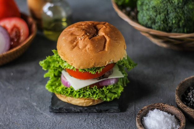 Fotografia świeży hamburger na drewnianej tnącej desce na zmroku