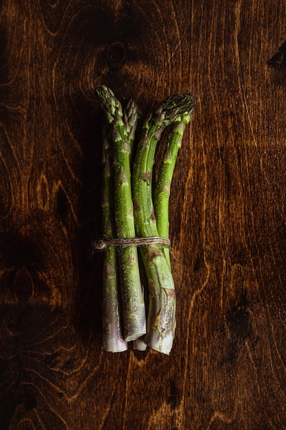 Fotografia świeżych produktów Zielone szparagi na drewnianym stole