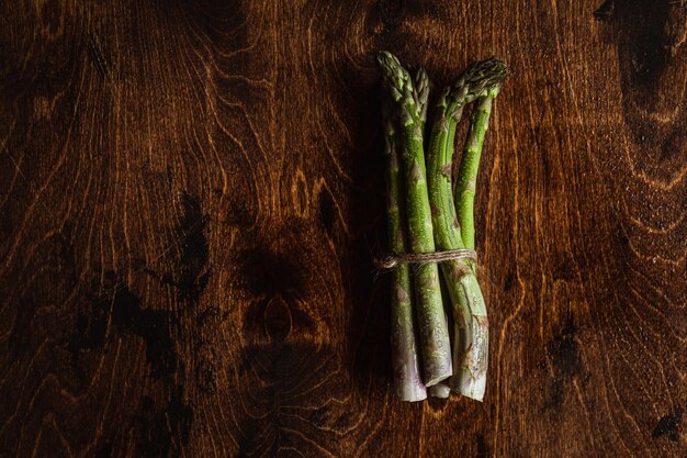 Fotografia świeżych produktów Zielone szparagi na drewnianym stole