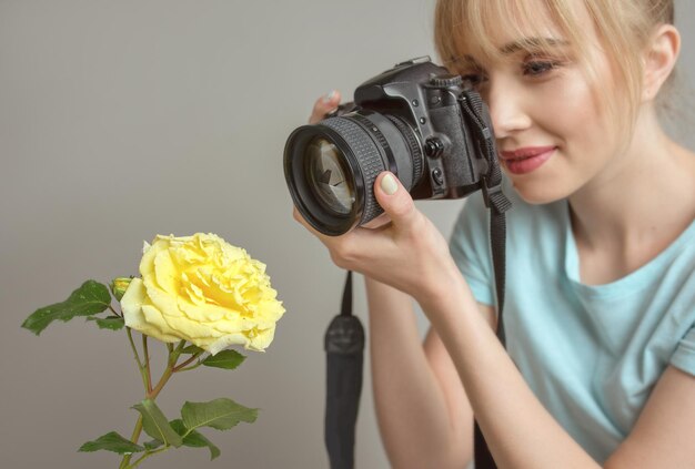 fotografka fotografująca żółtą różę aparatem cyfrowym