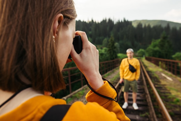 Fotografka Robi Zdjęcie Mężczyzny W Górach Na żelaznym Moście