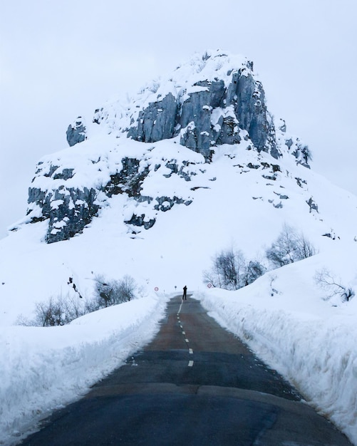 Fotografo De Paisaje En Medio De La Carretera Frente A Una Montana Completamente Nevada