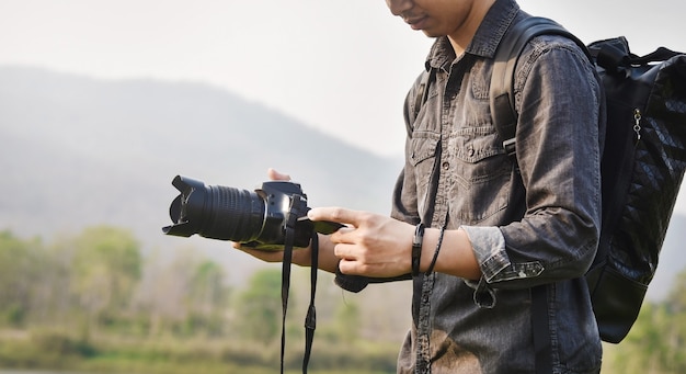 Fotografowanie widok krajobrazu, bliska młodych azjatyckich fotografów płci męskiej podczas trzymania aparatu