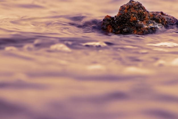 Fotografowanie wody otaczającej formację skalną w Namibii w Afryce o zachodzie słońca nad Oceanem Atlantyckim z długimi czasami otwarcia migawki