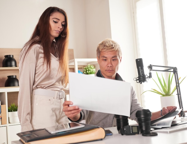 Fotografowie pracujący z laptopem w miejscu pracy z dwoma komputerami w studio