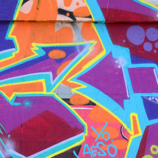 Fragment rysunków graffiti Stara ściana ozdobiona plamami farby w stylu kultury ulicznej Kolorowa tekstura tła w fioletowych odcieniach