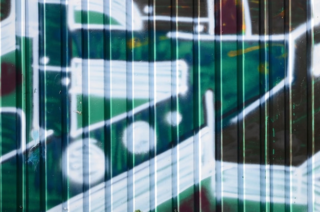 Fragment rysunków graffiti Stara ściana ozdobiona plamami farby w stylu kultury ulicznej Kolorowa tekstura tła w odcieniach zieleni