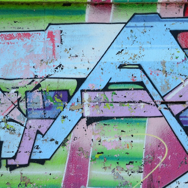Fragment rysunków graffiti Stara ściana ozdobiona plamami farby w stylu kultury ulicznej Kolorowa tekstura tła w zimnych tonach
