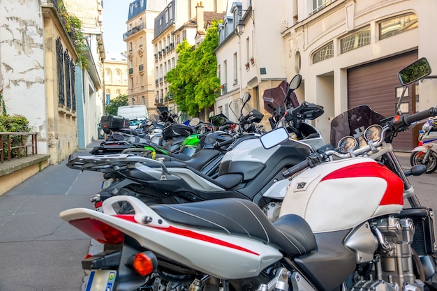 Zdjęcie francja, paryż. kilka motocykli zaparkowanych na letniej, słonecznej ulicy