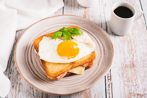 Francuska croque madame gorąca kanapka śniadaniowa na talerzu na stole