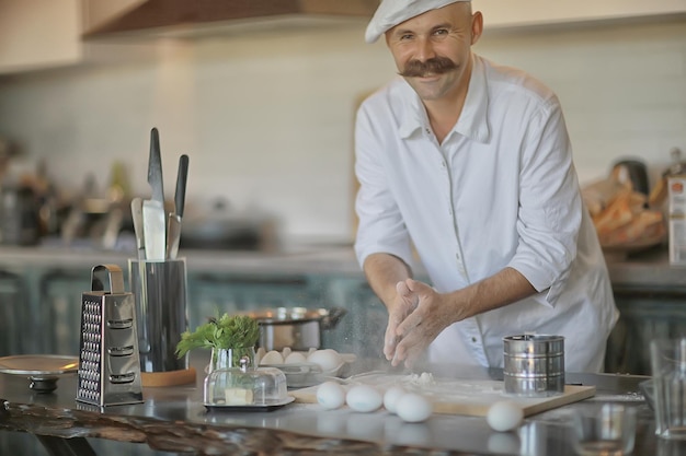 francuski szef kuchni w kuchni przygotowujący jedzenie, gotujący, haute cuisine, mężczyzna z wąsami