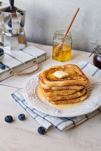Francuskie tosty z masłem i jagodami na śniadanie.