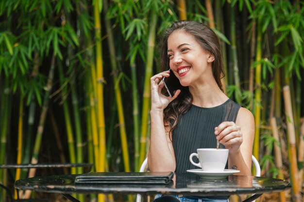 Francuzka rozmawia z telefonem na tarasie kawowym