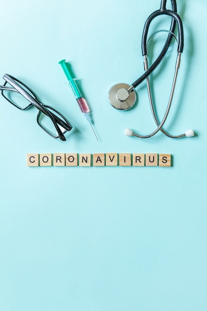Fraza tekstowa Koronawirus ze strzykawką, okularami i stetoskopem