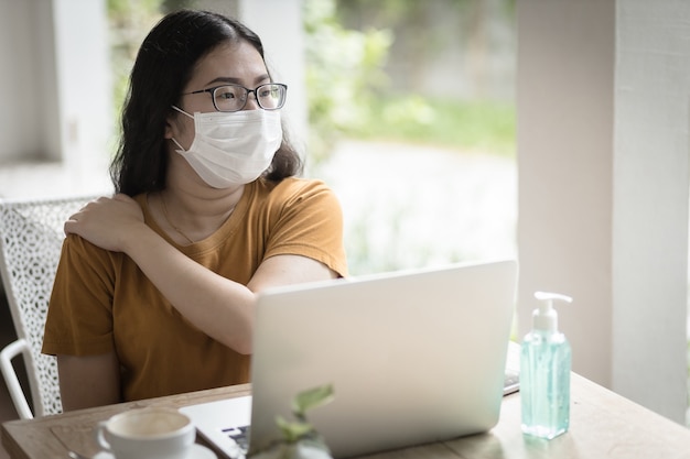 Freelance People Business Woman Nosząca Maskę Ochronną Na Co Dzień Cierpi Na Ból Ramion Podczas Pracy Z Laptopem, Pracując W Domu, Koncepcja Zapobiegania Rozprzestrzenianiu Się Wirusa Covid-19