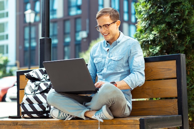 Freelancer cieszący się czasem spędzonym na świeżym powietrzu podczas pracy zdalnej na laptopie