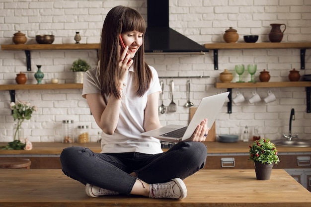 Zdjęcie freelancer dziewczyna pracuje przy komputerze i dzwoni na telefon