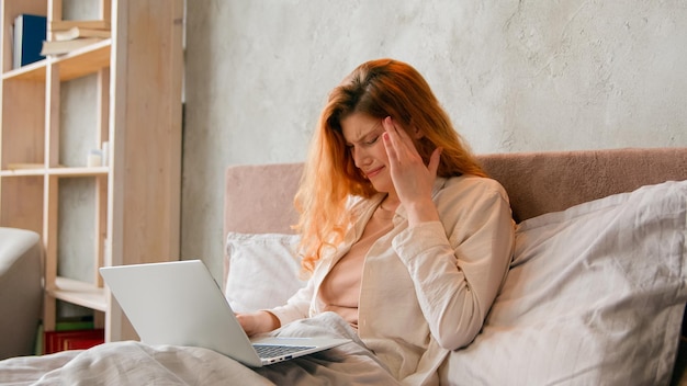 Freelancer kaukaska chora kobieta pracująca zdalnie z domowego łóżka złe samopoczucie ból głowy chora studentka