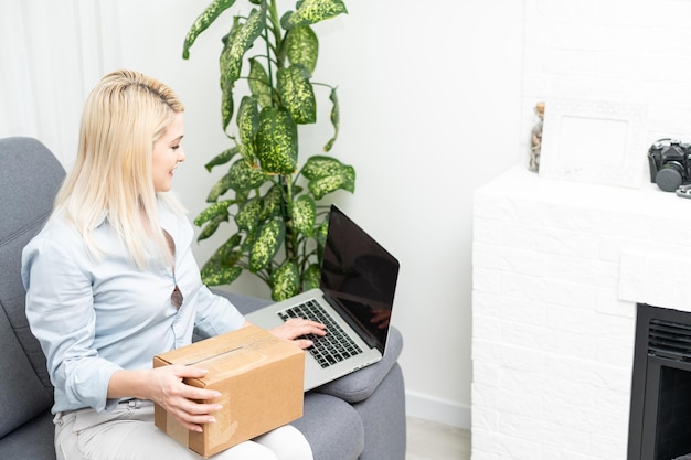 Zdjęcie freelancer kobieta biznes prywatna praca w biurze w domu wnętrze uśmiech sprawdzanie zamówienia z laptopa dla klienta i dostawa online do gotowego pakowania na stole roboczym