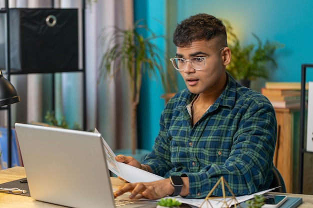 Freelancer księgowy pracuje z dokumentami graficznymi finansowymi, oblicza podatki dla wykresów w biurze