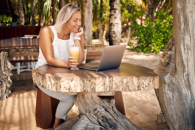 Freelancer Woman Work by Laptop in Tropical Cafe