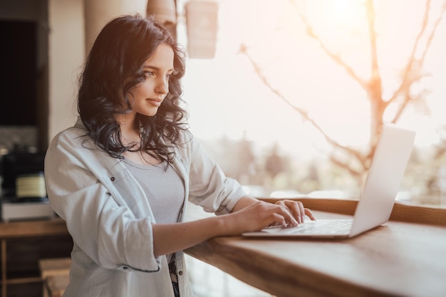 Freelancerka korzystająca z laptopa w kawiarni