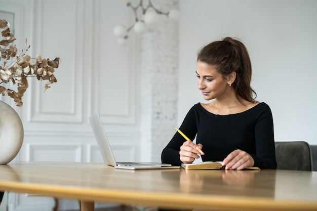 Freelancerka pracująca w biurze korzysta z laptopa