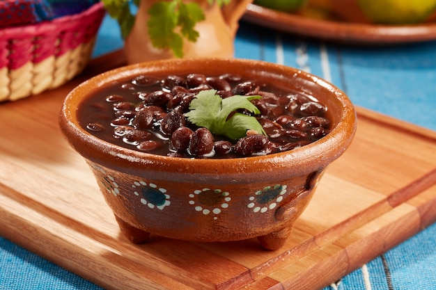 Zdjęcie frijoles negros mexicanos servidos en plato de barro comida mexicana