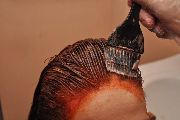 Fryzjer farbujący włosy klienta