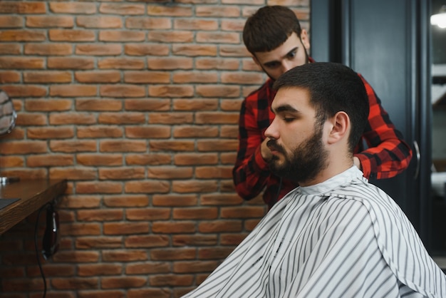 Fryzjer. Mężczyzna z żoną na fotelu fryzjerskim, fryzjer Barbershop stylizuje mu włosy