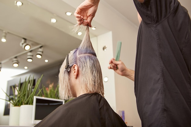 Fryzjer strzyżenia kobieta blond włosy w salonie piękności