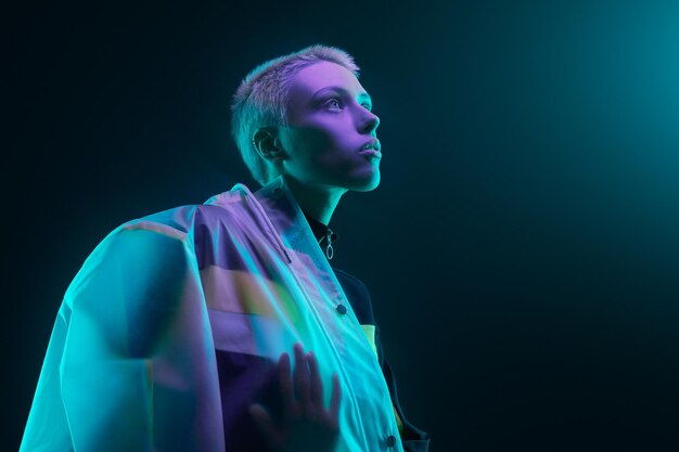 Futurystyczna młoda kobieta patrząca na światło neonowe