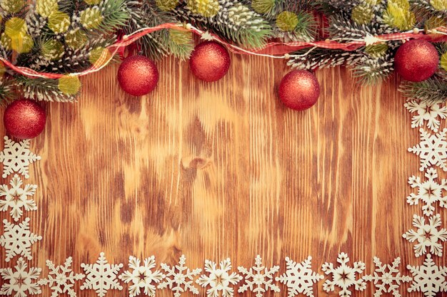 Gałąź choinki z dekoracjami na tle drewna. Koncepcja świątecznych wakacji