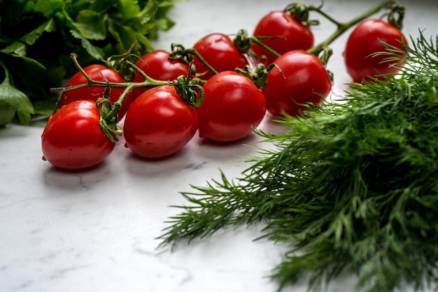 Zdjęcie gałąź pomidorów wiśniowych przez zieloną pietruszkę składniki sałatki z widokiem bocznym zbliżenie